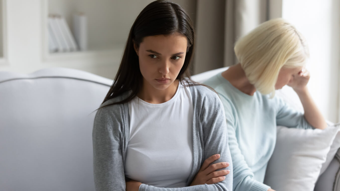 Une jeune adolescente fâchée à côté de sa maman.