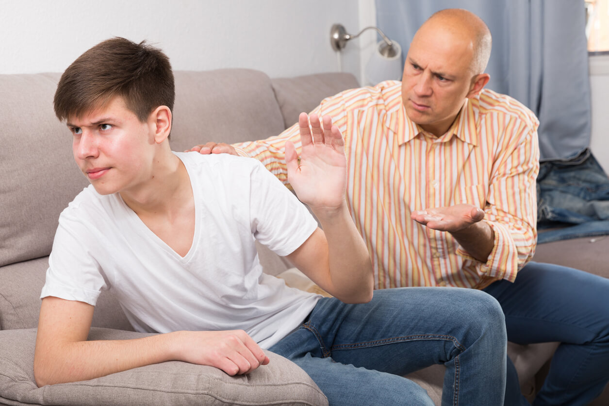 A teenager turning away from his father during an argument.
