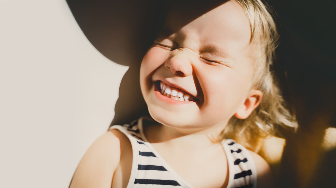 Un enfant qui sourit au soleil.