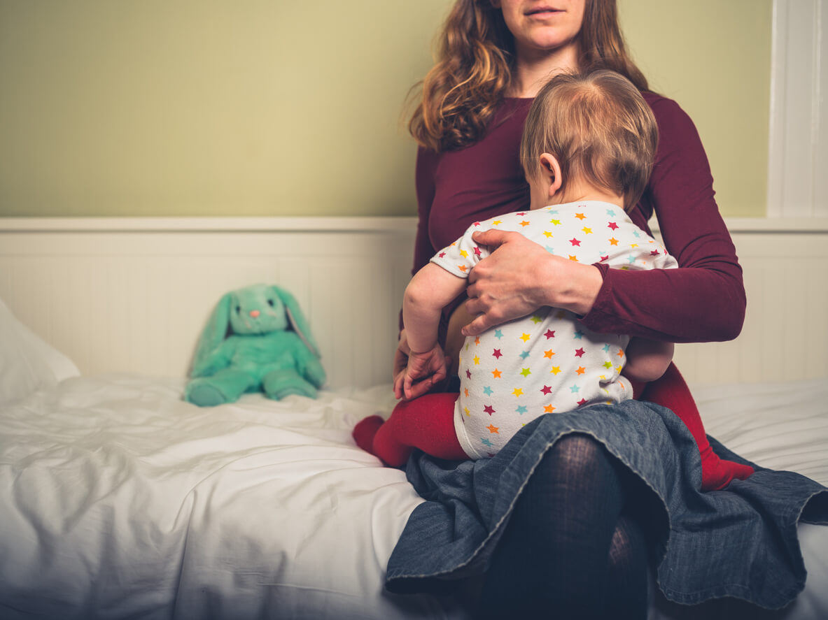 Une maman qui allaite son enfant dans on lit.
