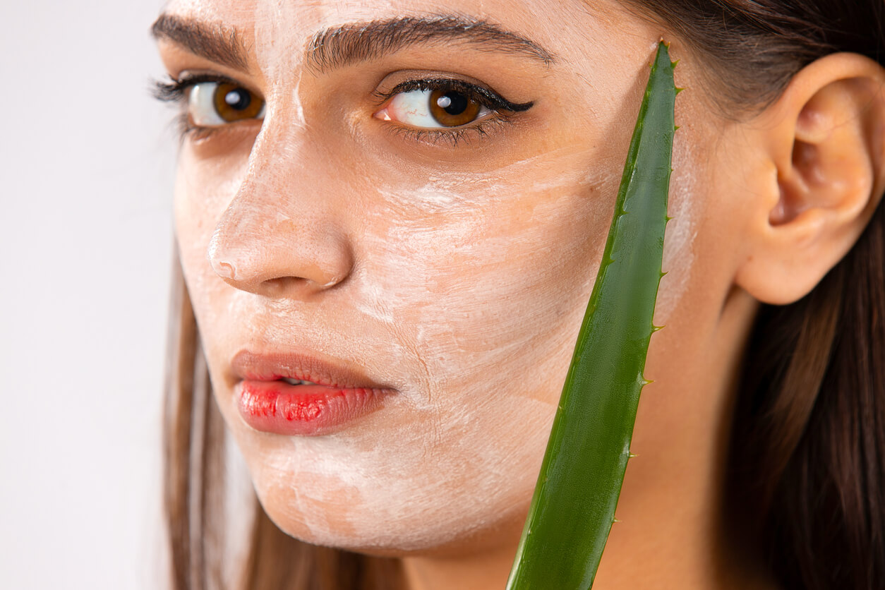 En kvinna som applicerar en ansiktsmask med Aloe vera.