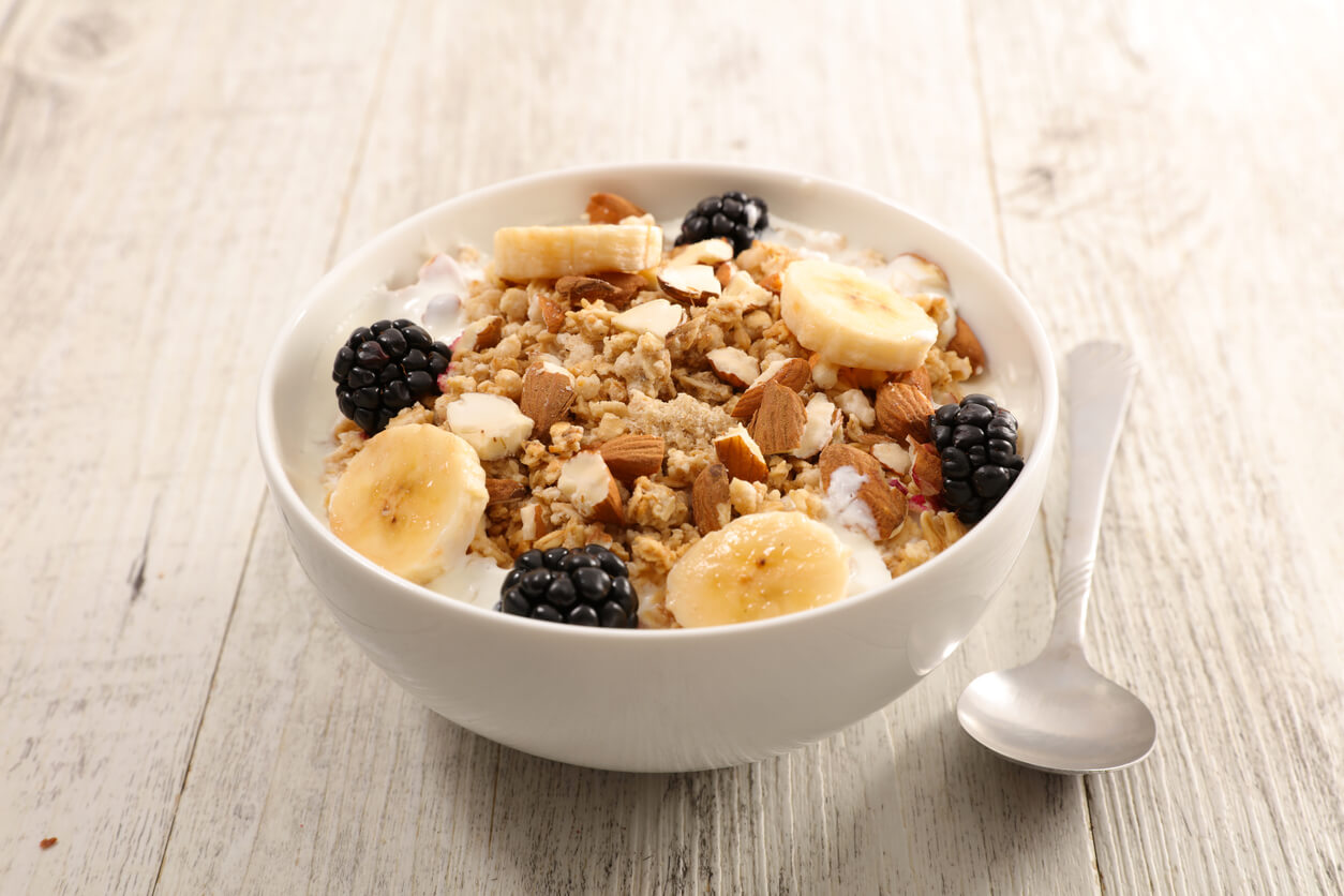 A bowl of yogurt with granola, banana, and berries.