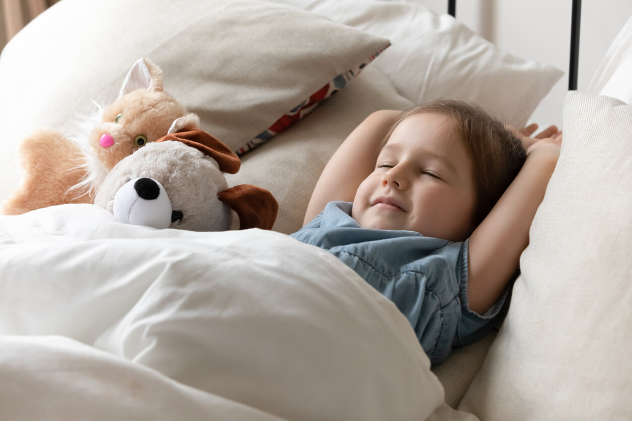 A toddler girl reasting peacefully in bed.