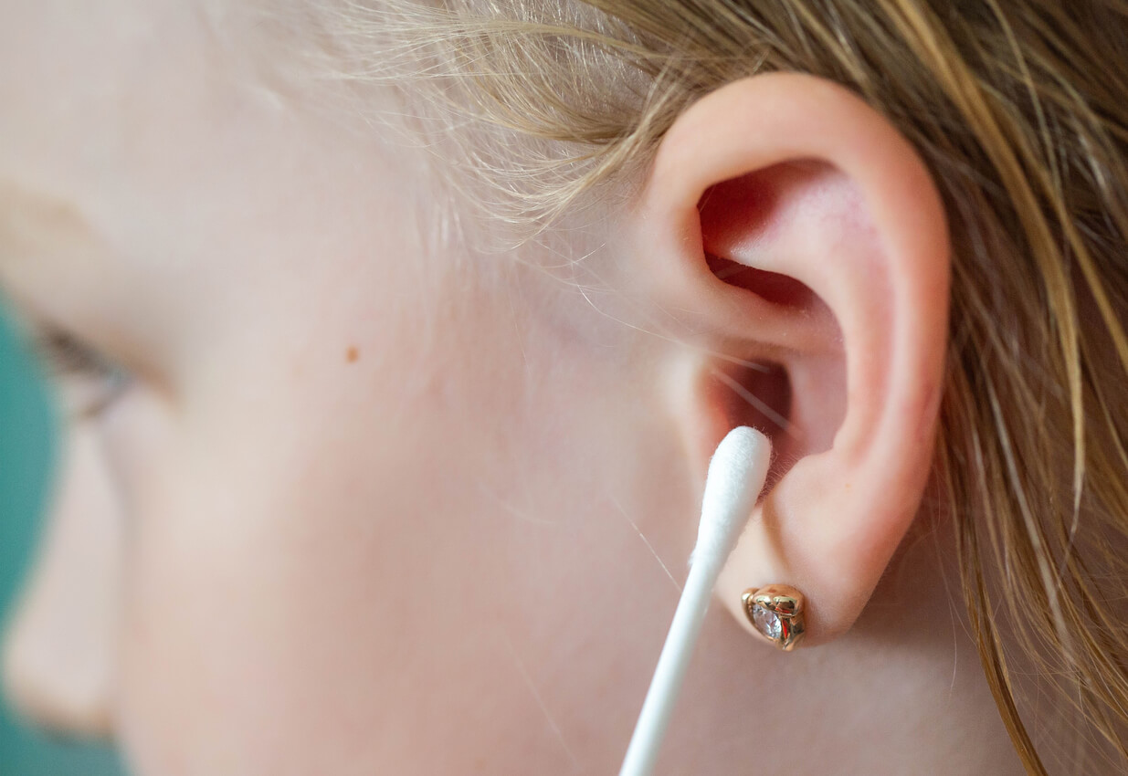 Oreille d'un enfant avec un coton-tige.