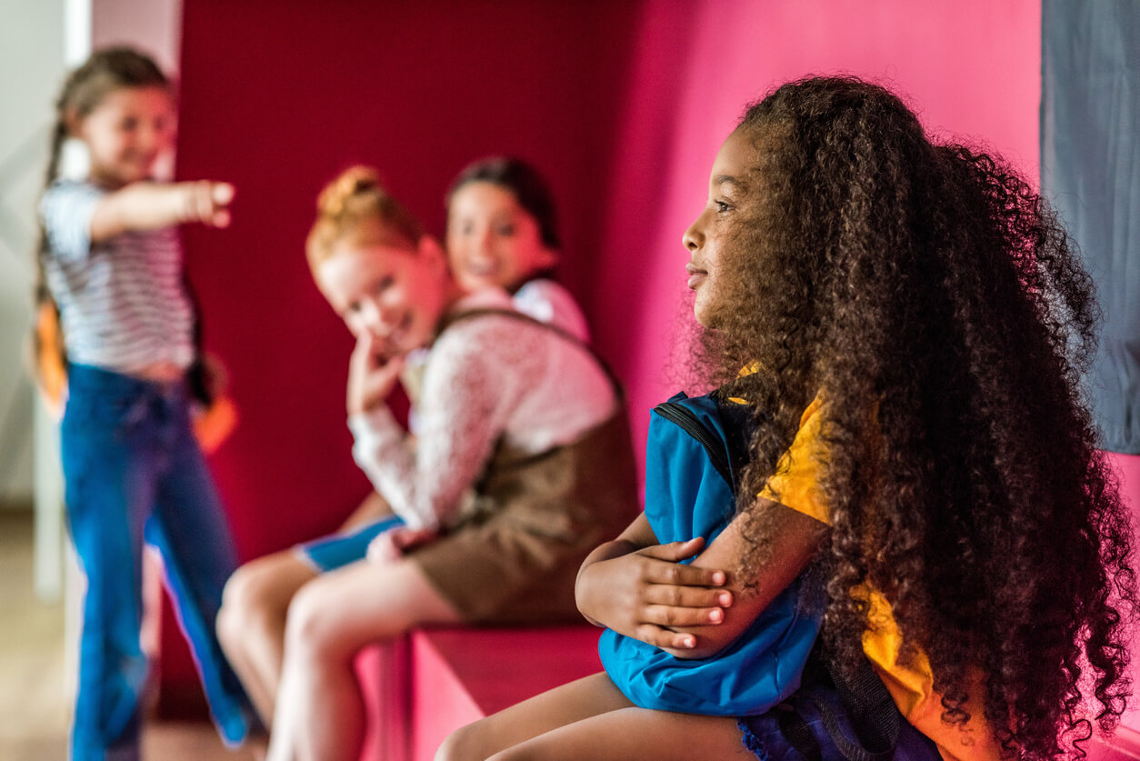 Des jeunes filles qui se moquent d'une camarade à la peau plus foncée.