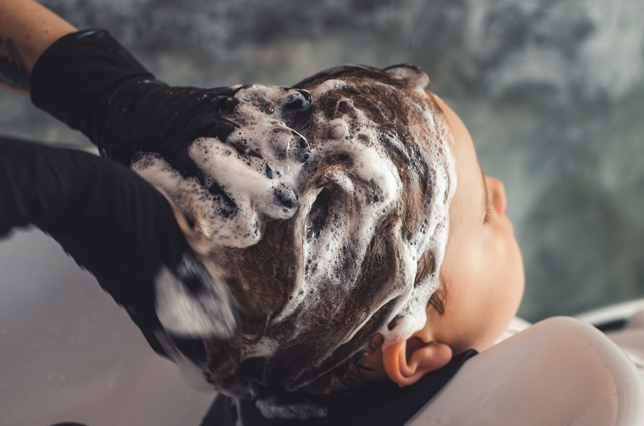 A hairdresser washing a child's hair.