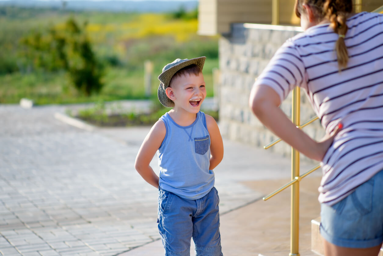 A child who's laughing while his mother colds him.