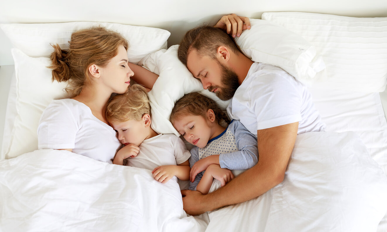 Une famille qui dort dans le même lit.