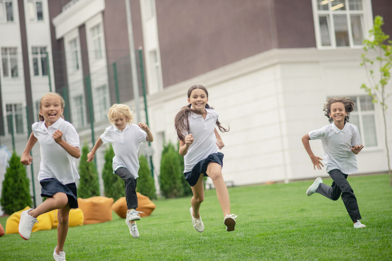 Barn som løper i en skolegård.