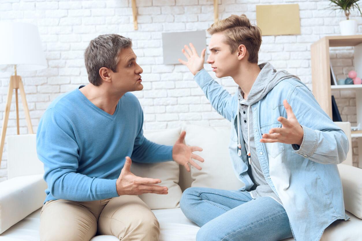 A teen arguing with his father because of parental alienation syndrome.