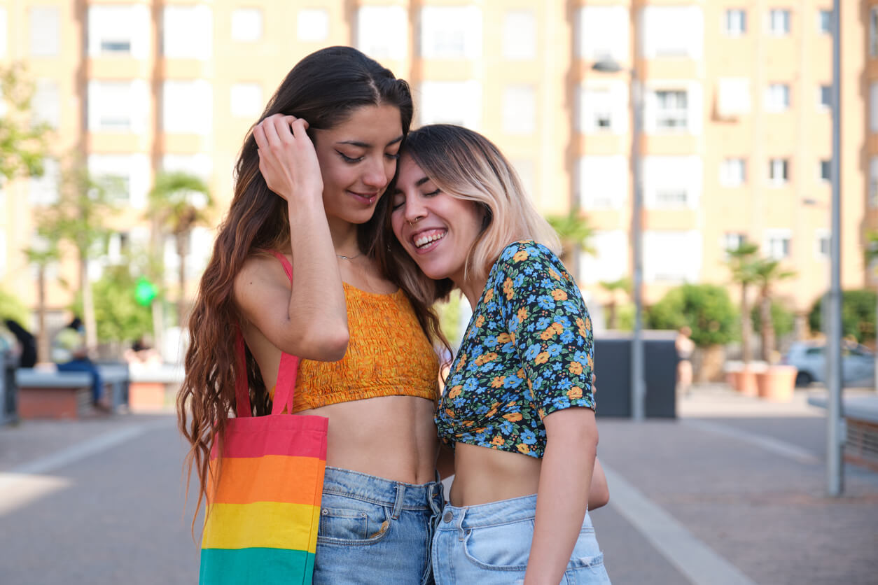 Deux jeunes femmes l'une contre l'autre dans la rue.