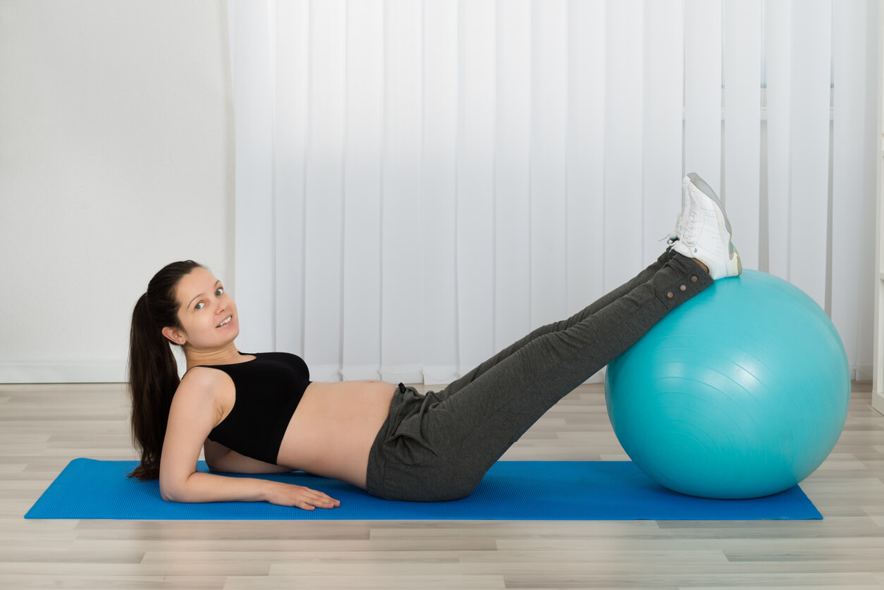 Une femme enceinte avec une fitball.