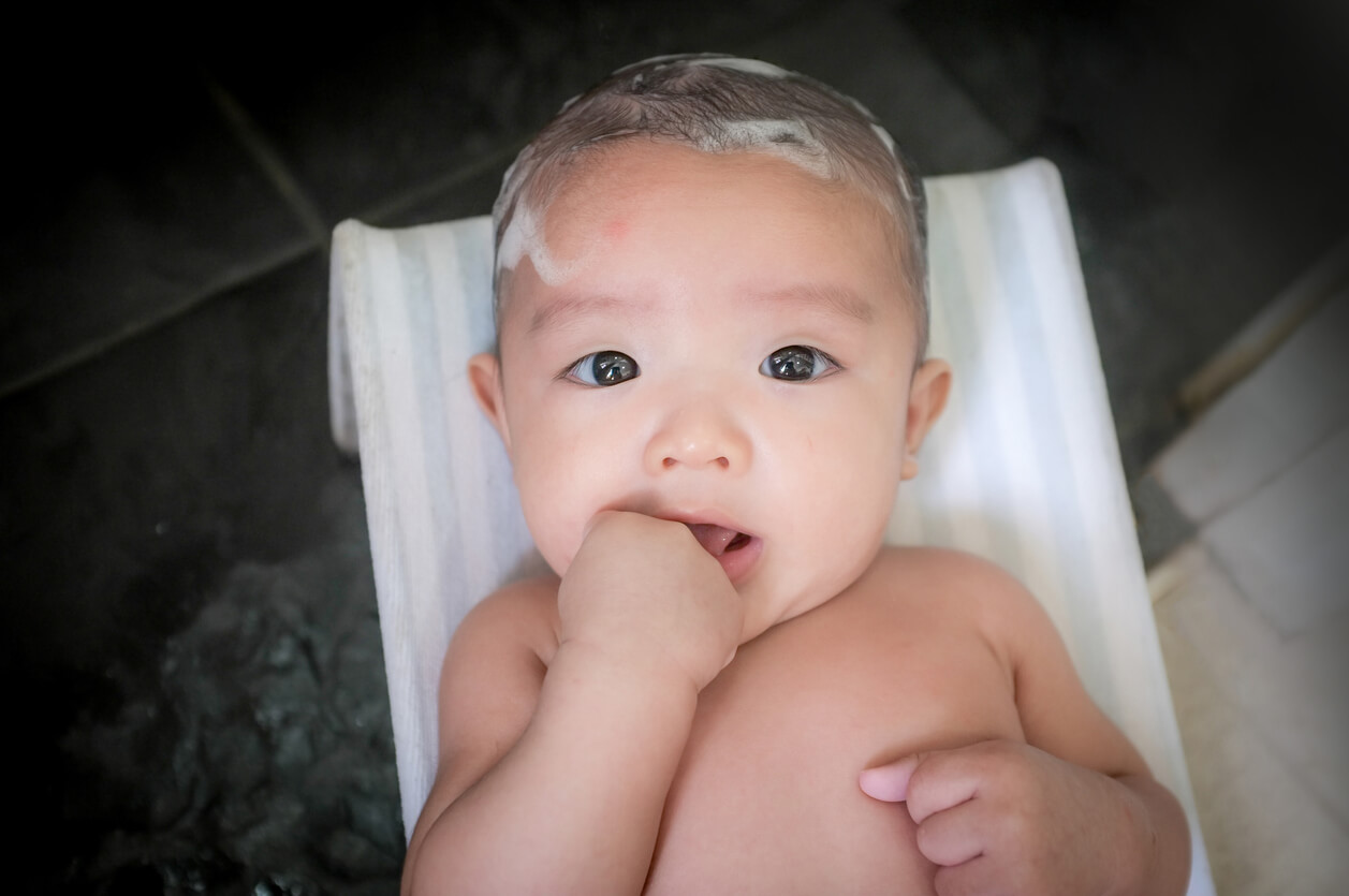 Un bébé avec un shampoing sur la tête.