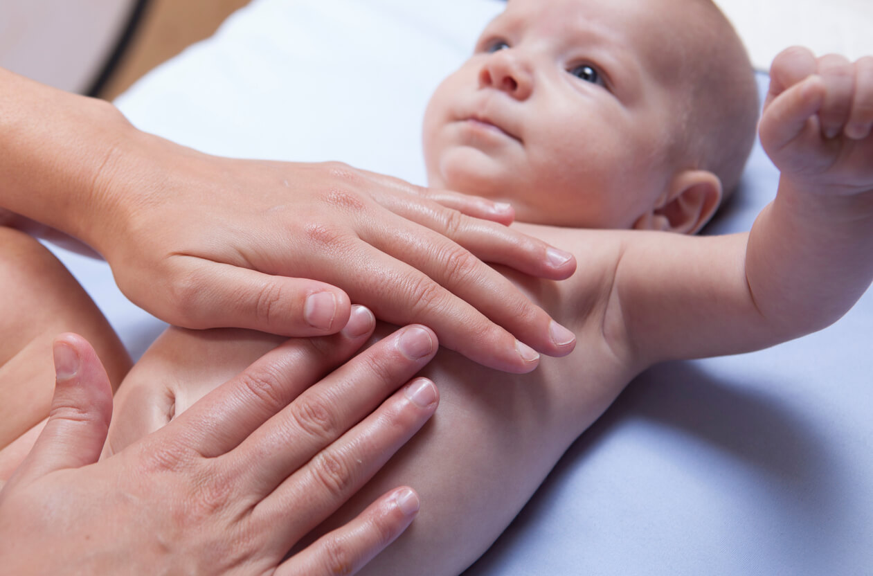 A doctor checking a baby's belly.