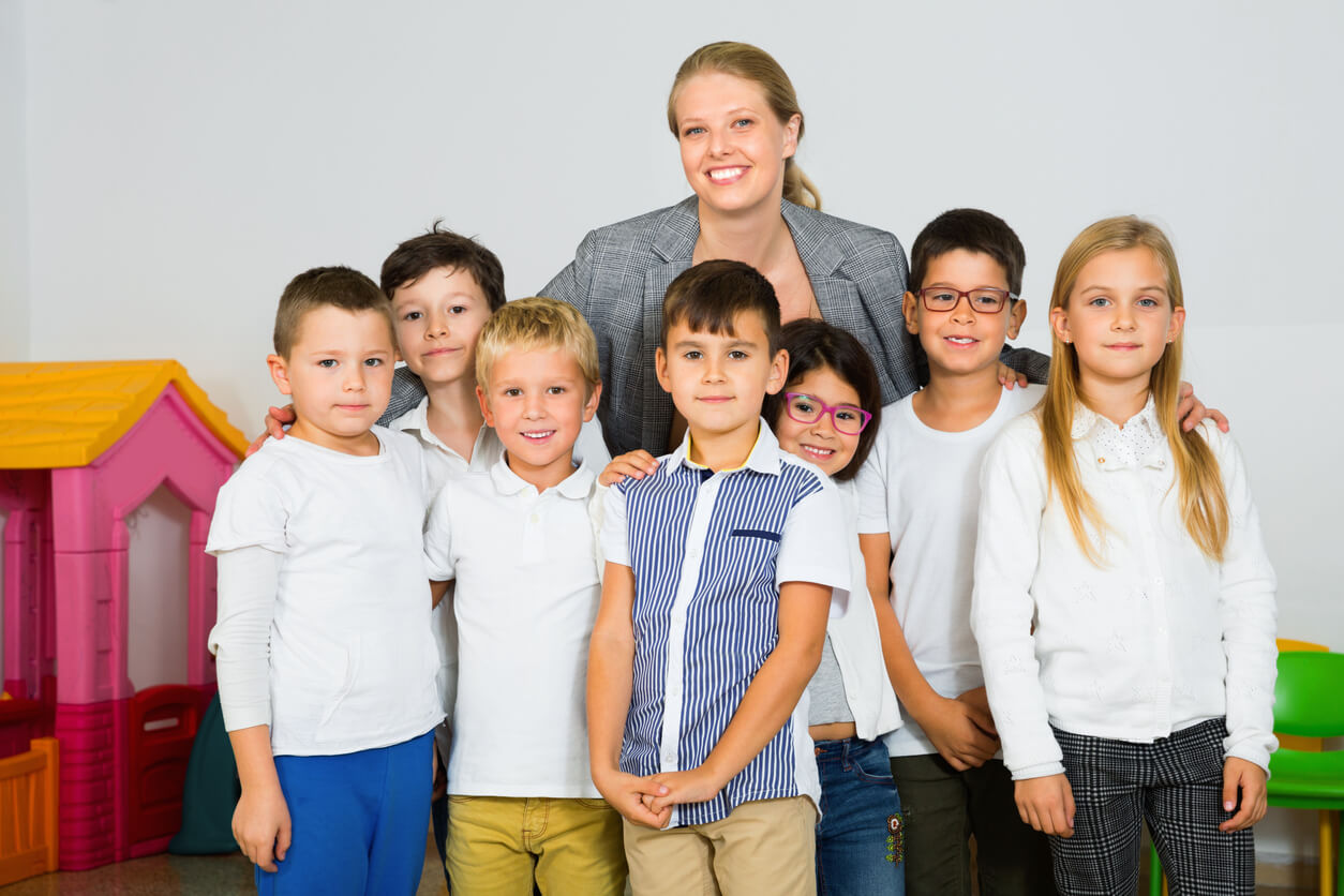 A teacher posing behind her students.