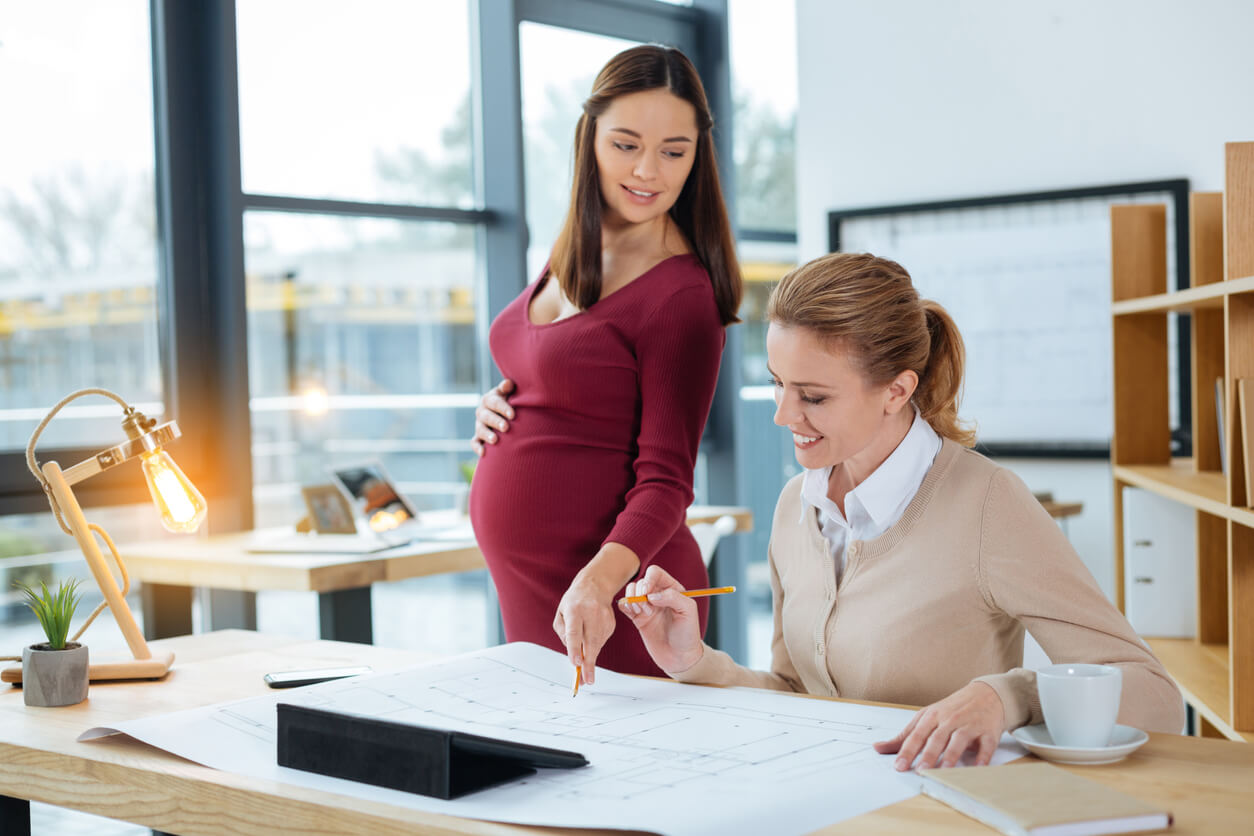 A pregnant woman working in an office setting.
