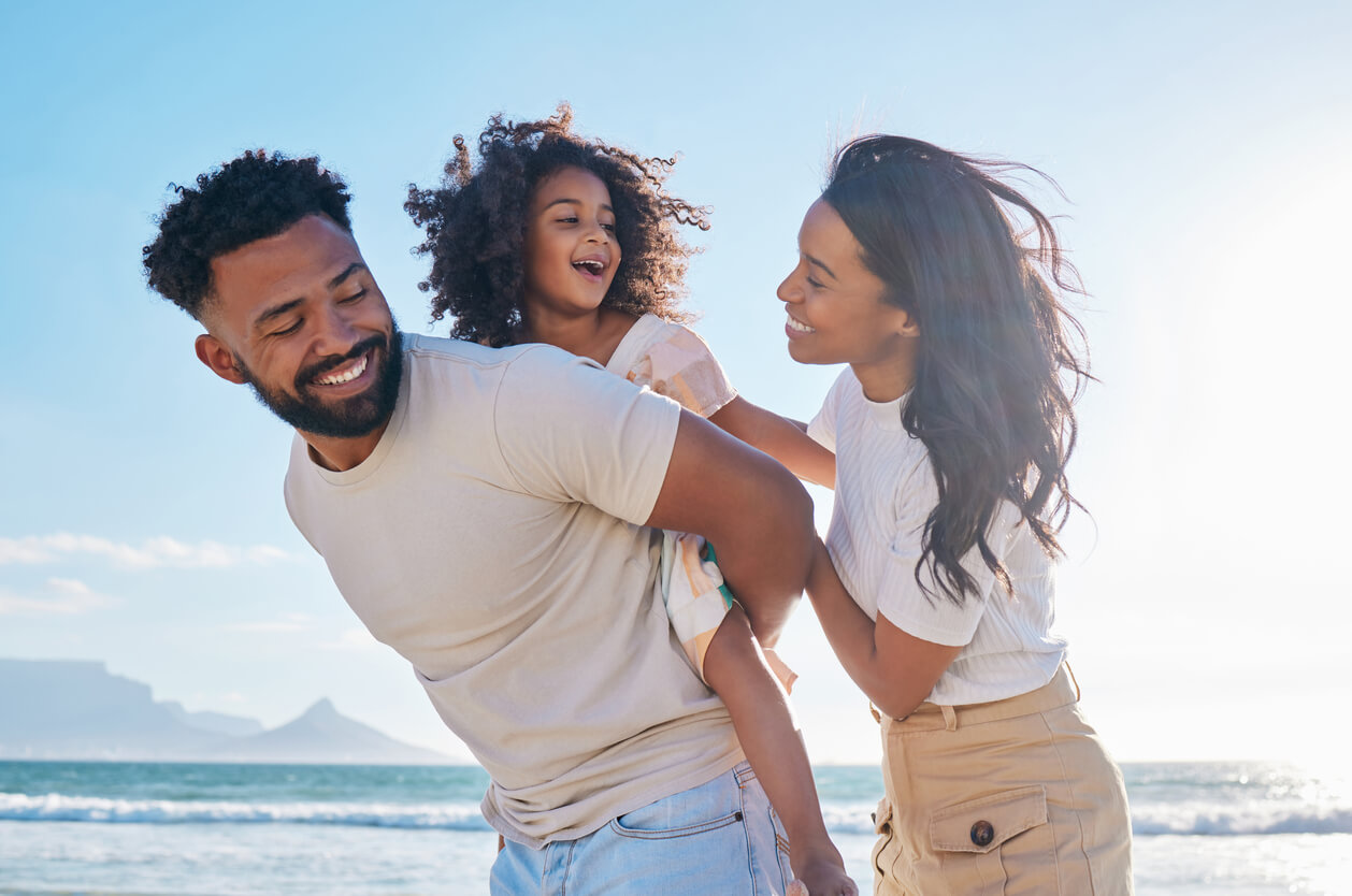 Parents playing with their daughter on the beach?