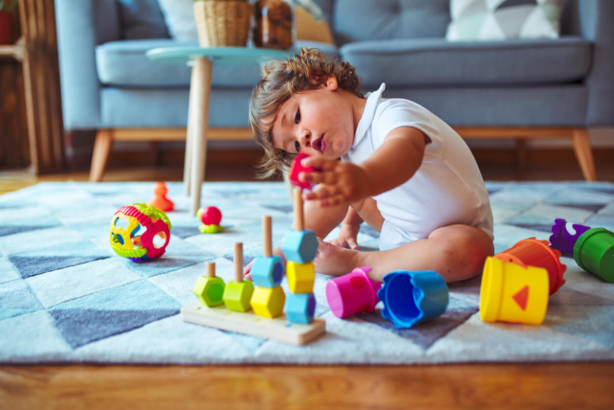 A toddler playing with toys on the floor.