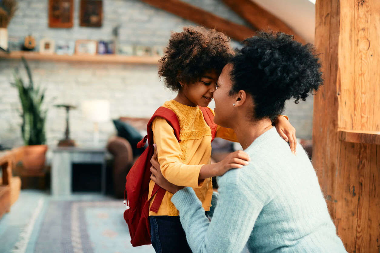 A black mother and her daughter touching forheads lovingly.