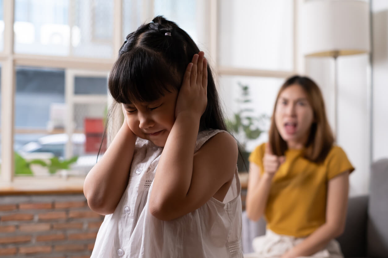 Une jeune fille qui se bouche les oreilles et refuse d'écouter sa mère. 