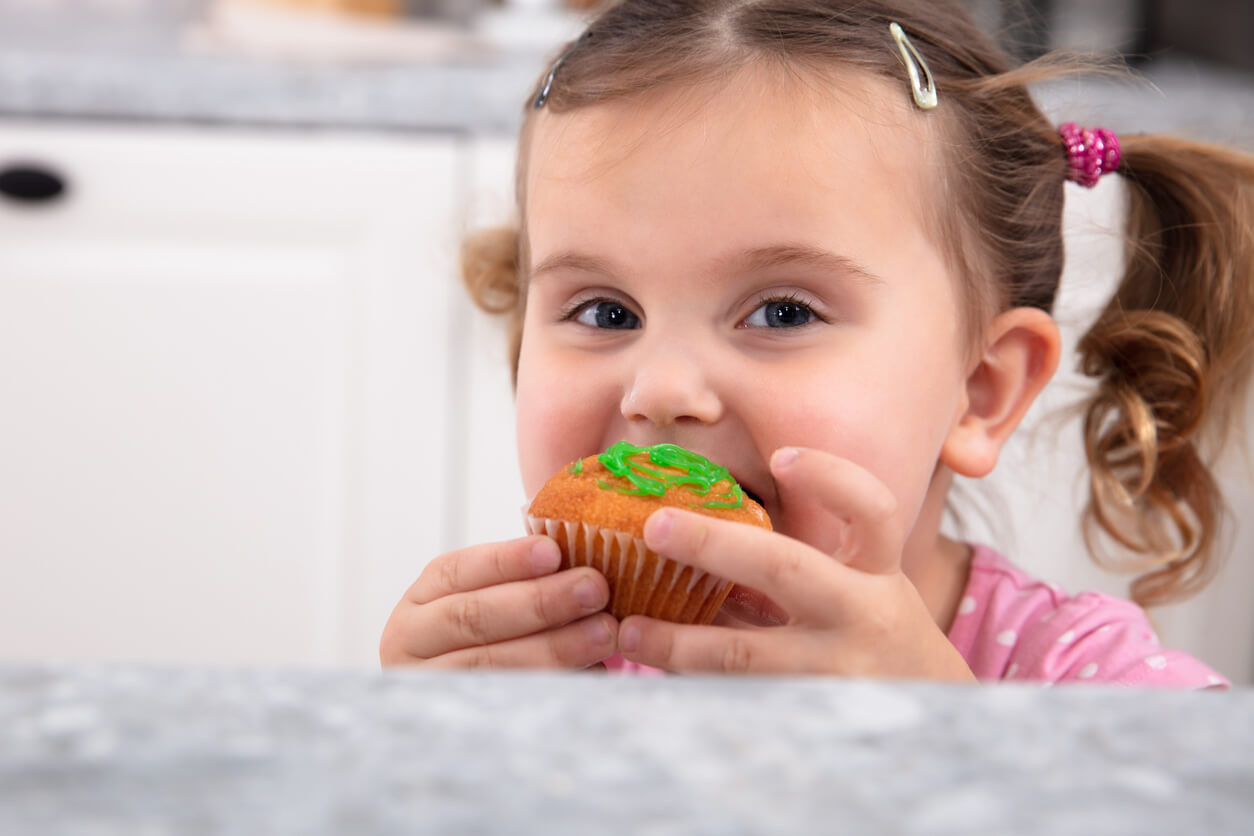 Een meisje eet een cupcake