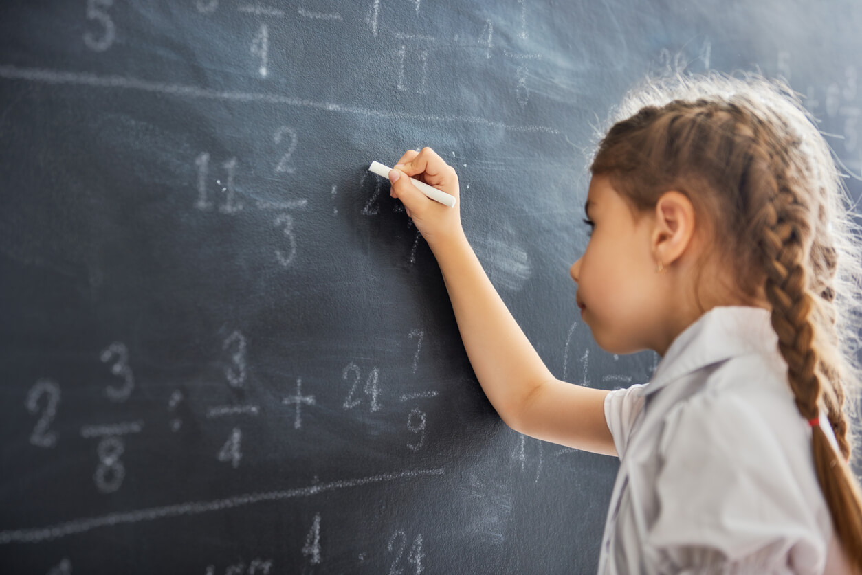 En ung jente som gjør matematikk på en tavle.