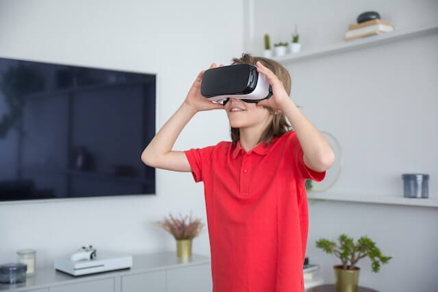 Niño emocional con gafas vr y tablet pc. aislado sobre fondo gris.