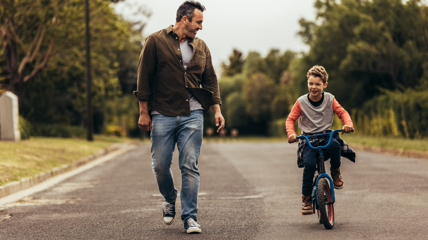 A father teaching his son to ride a bike.