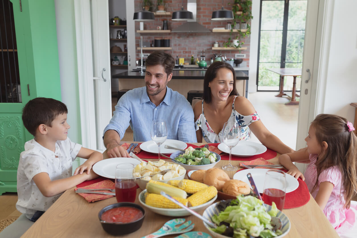 A family sitting down at the table for dinner.