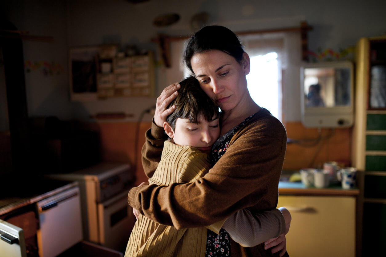 A mother and her son hugging.