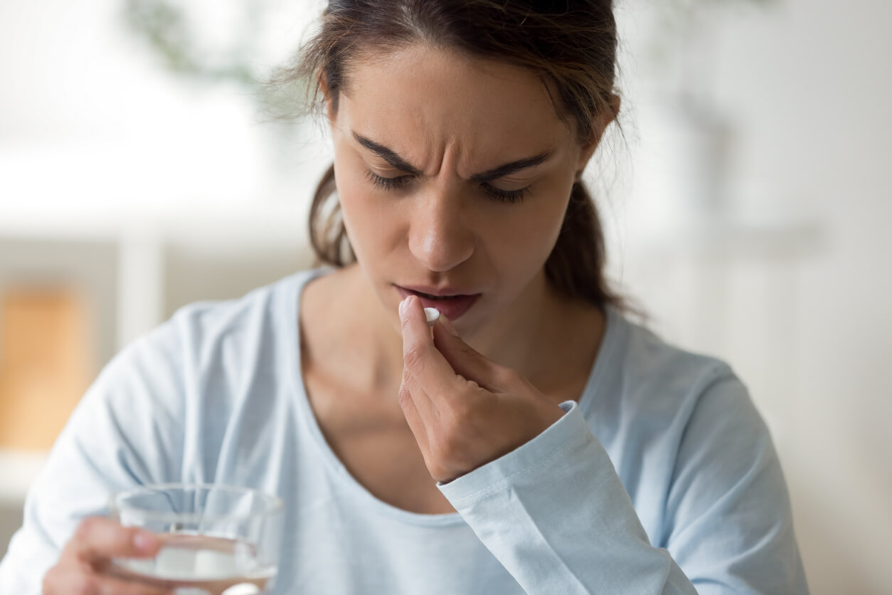 Une femme qui prend un médicament.