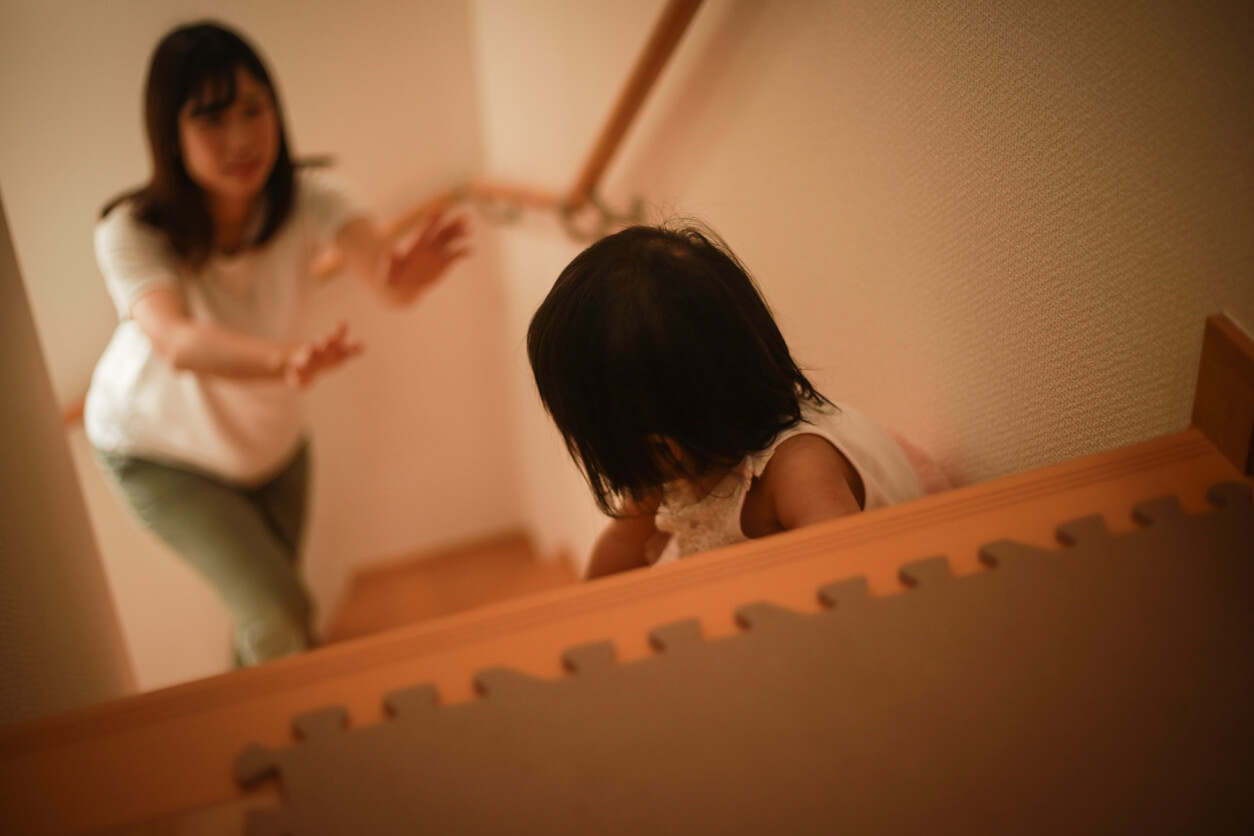 Une jeune fille dans les escaliers avec sa maman.