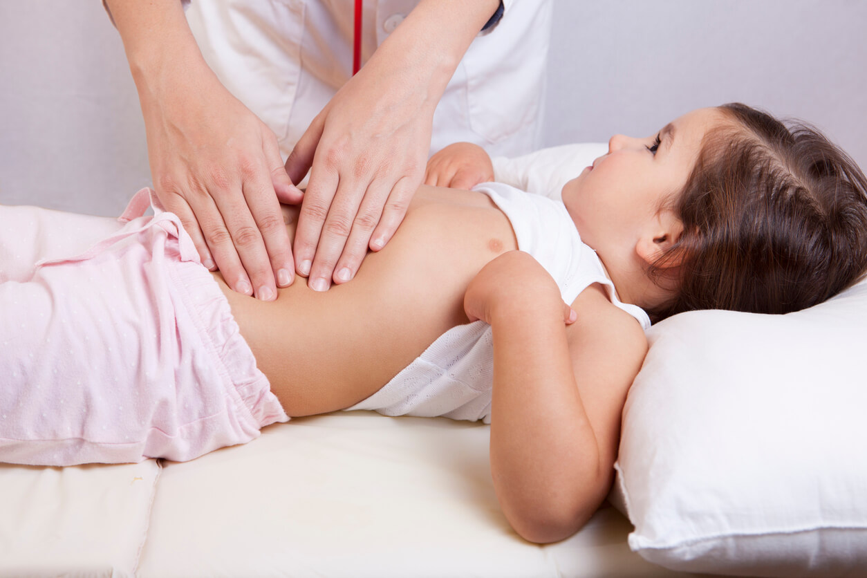 A doctor examining a child's abdomen.