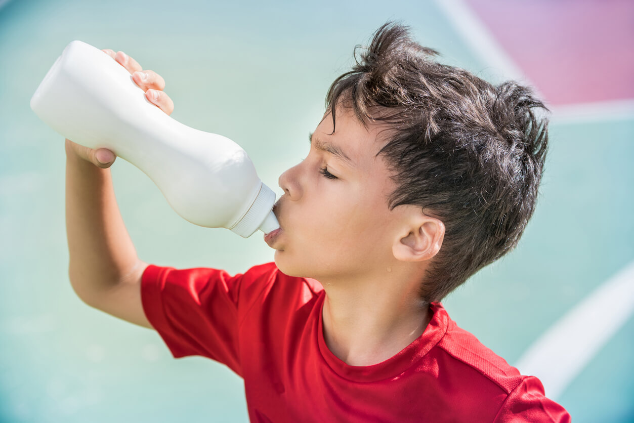 Een jongen drinkt een sportdrankje