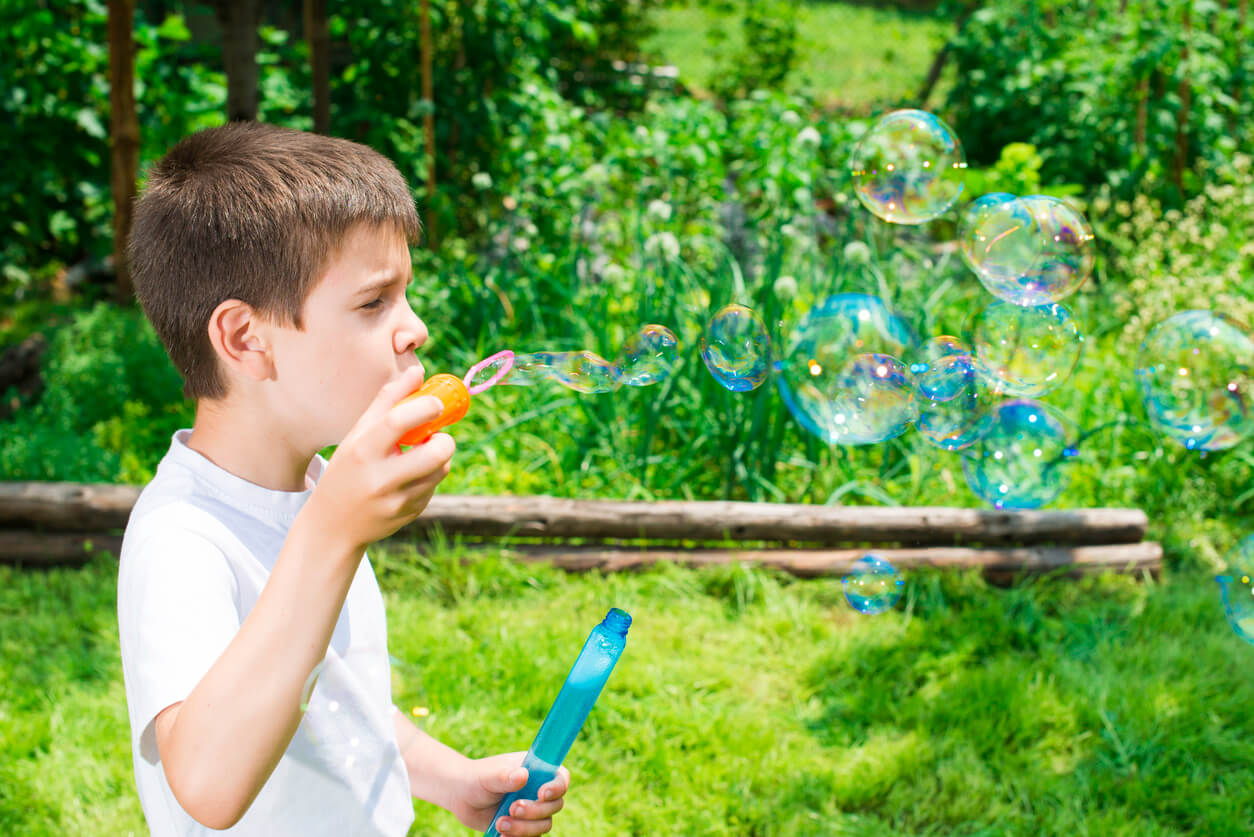 A child blowing bubbles outdoors.