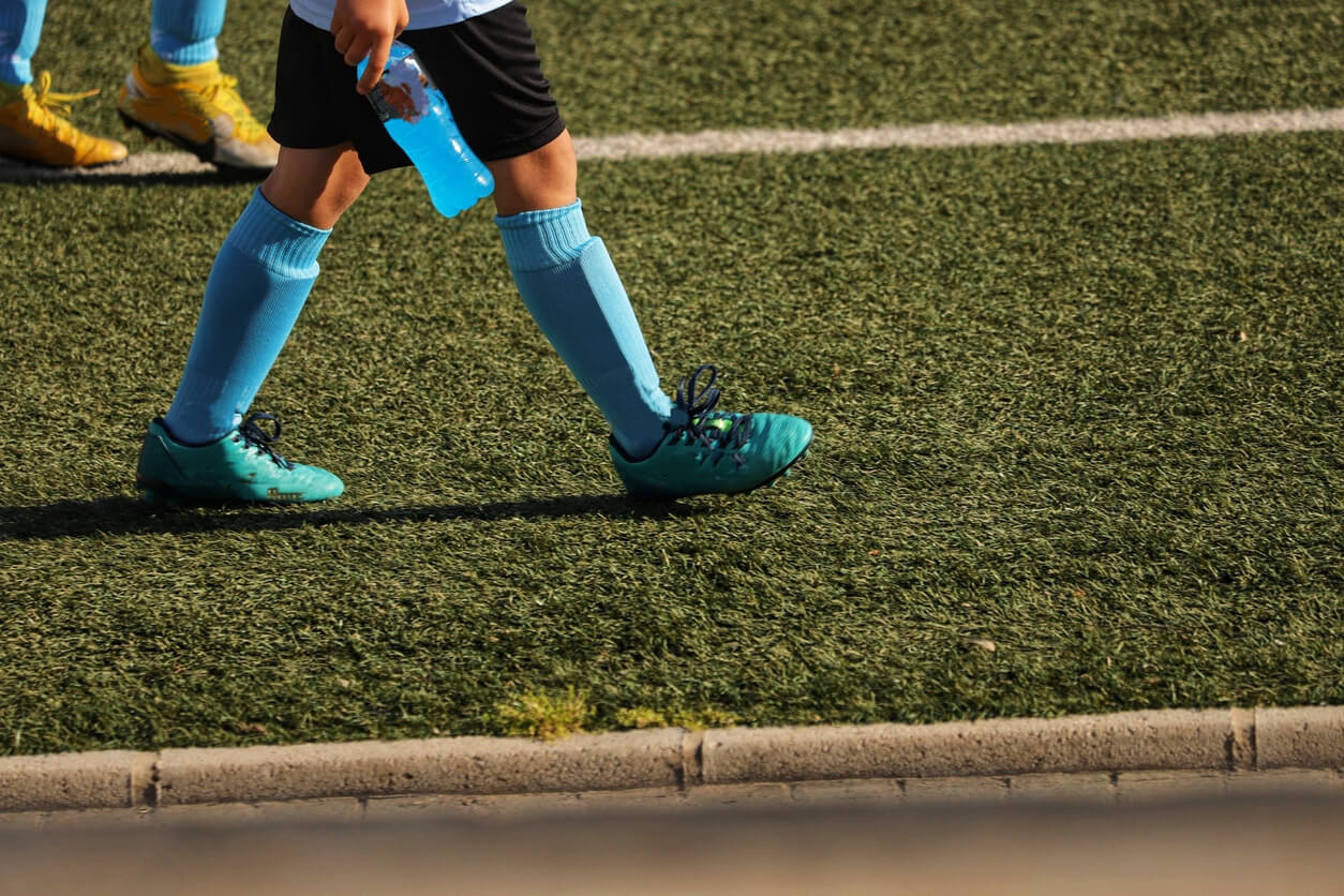 A soccer player carrying a sports drink.