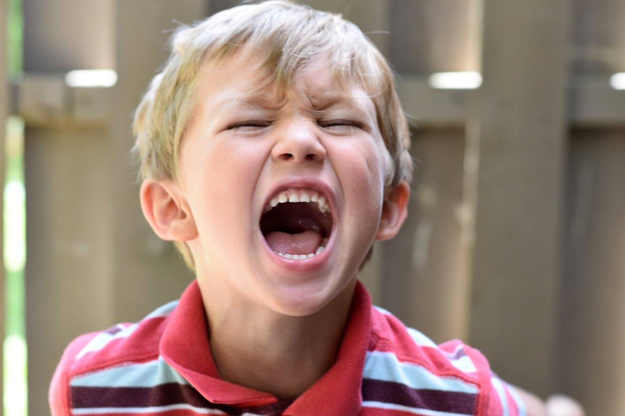 A young child screaming angrily.