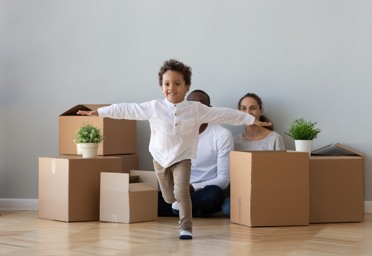 A child running in the house, pretending to be an airplane.