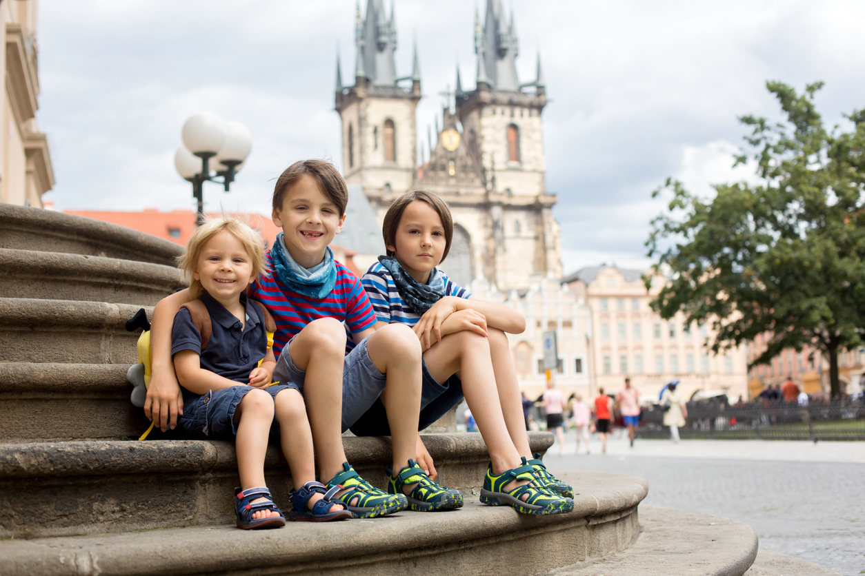 Three Slavic boys sitting by a fountain.