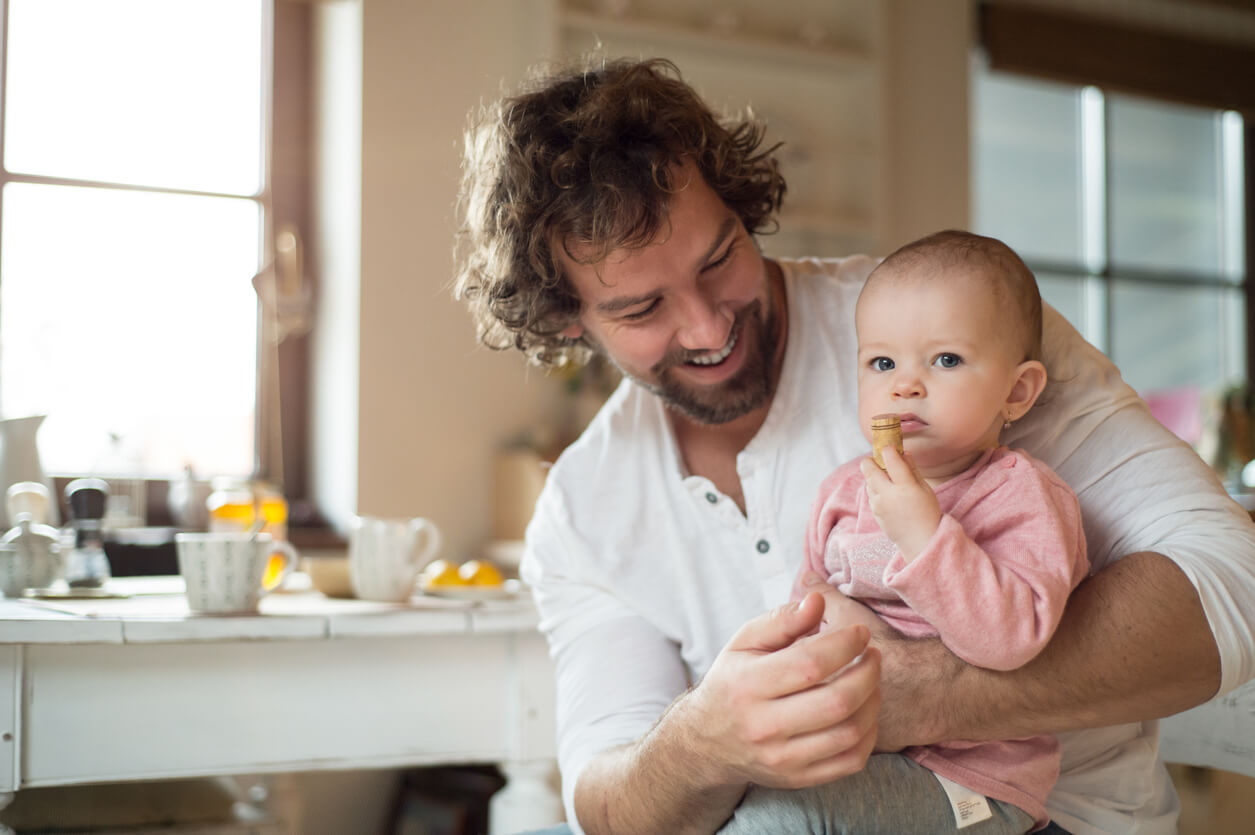 A father sitting with his baby girl on his lap.