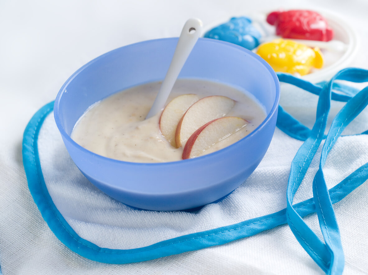 A bowl of oatmeal puree with apple slices.