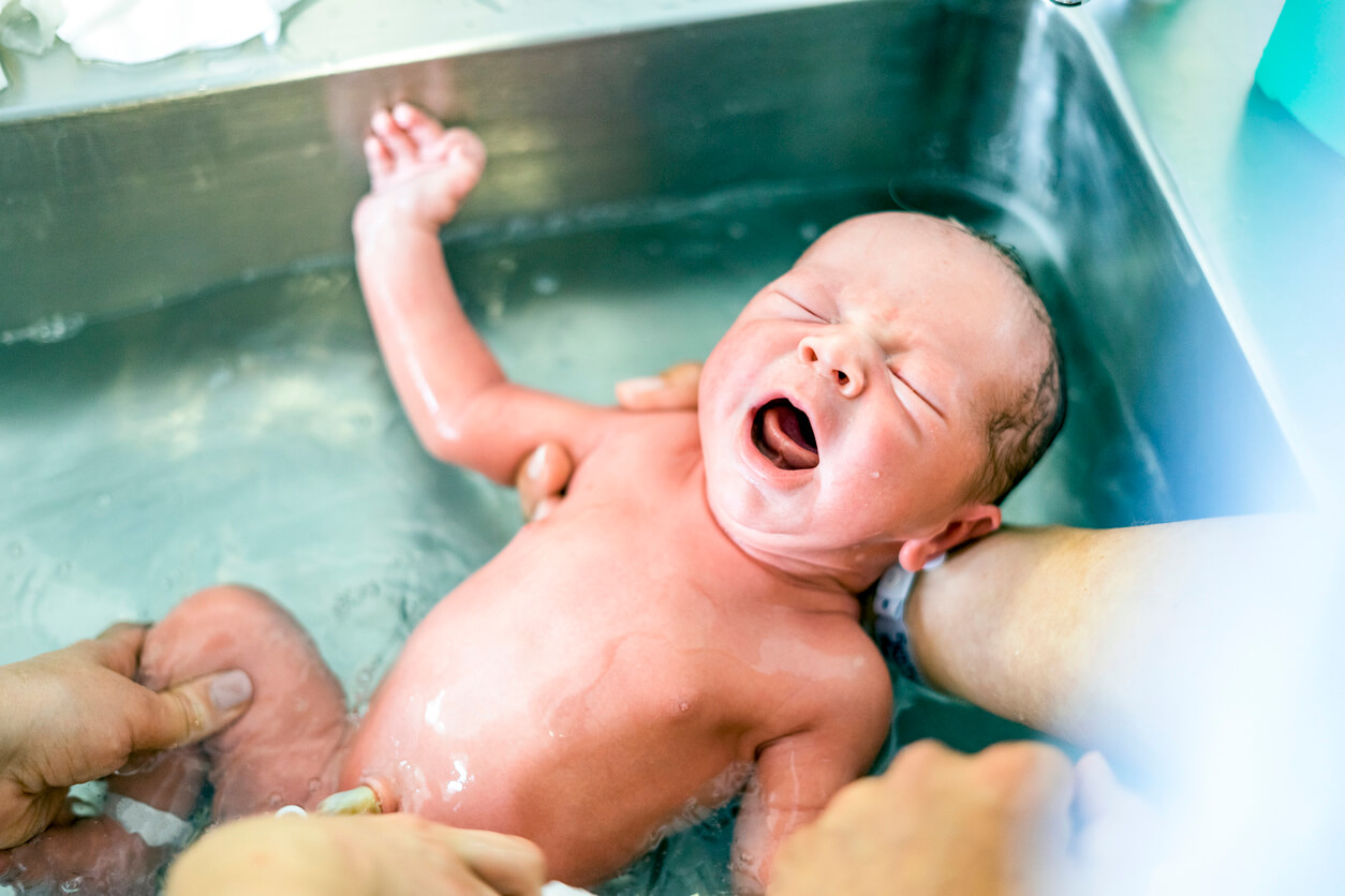 A newborn baby is being bathed at the hospital.