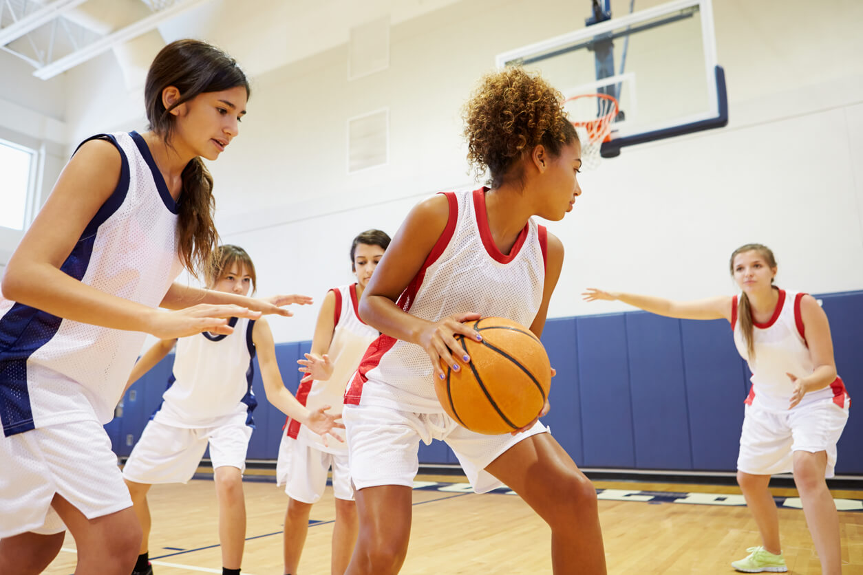 Teen girls playing basketball.