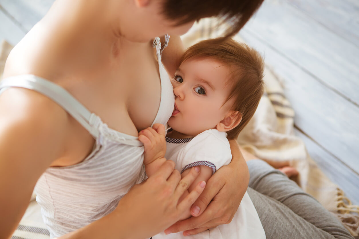 A baby looking up while she breastfeeds.