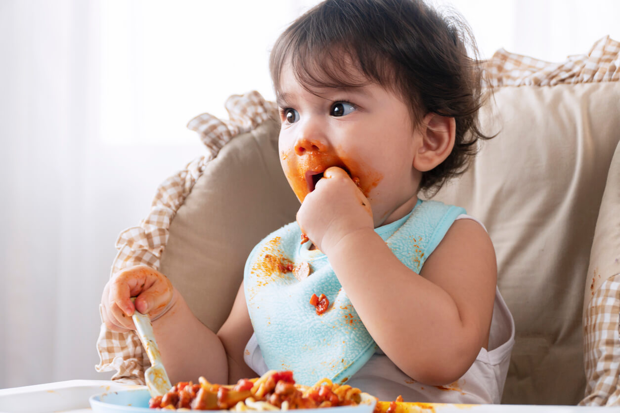 Un enfant qui mange avec les mains.