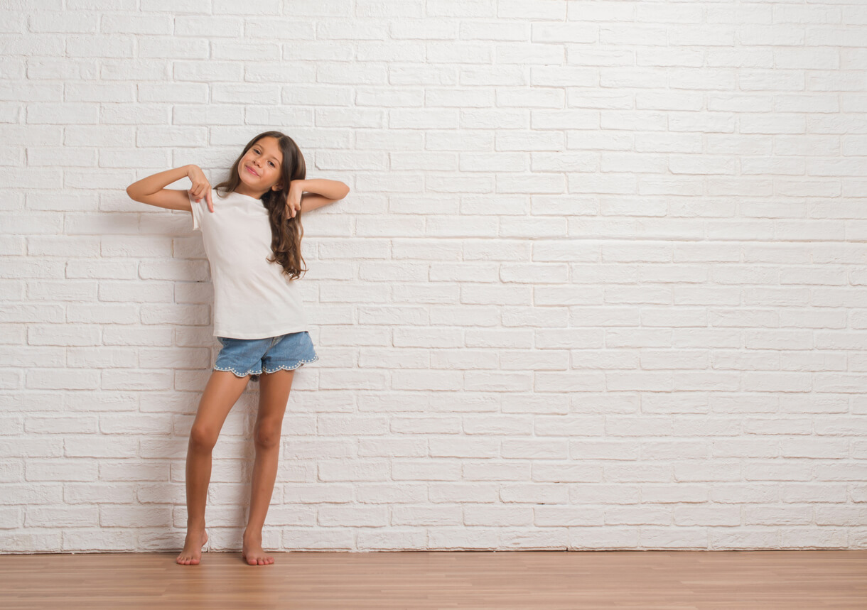 Une jeune fille contre un mur. 