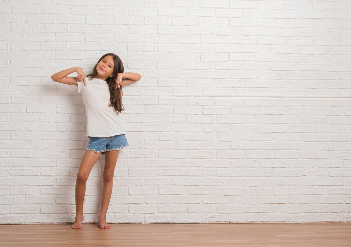 A young girl standing standing in an arrogant pose.