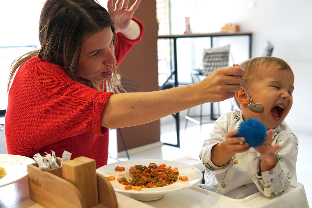 Une jeune femme qui donne à manger à un enfant. 