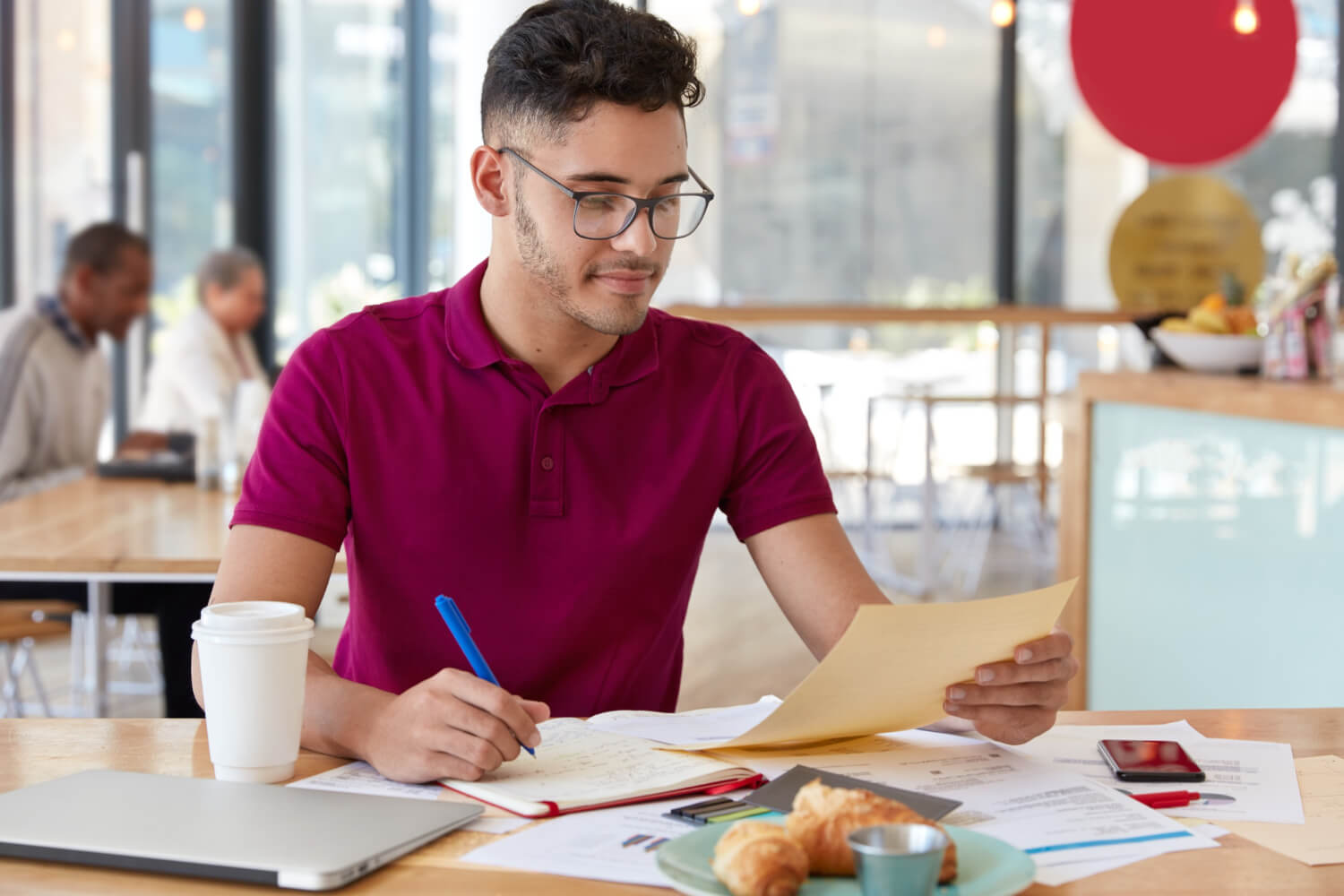 A teenager sitting in a cafe, carrying out a job search.