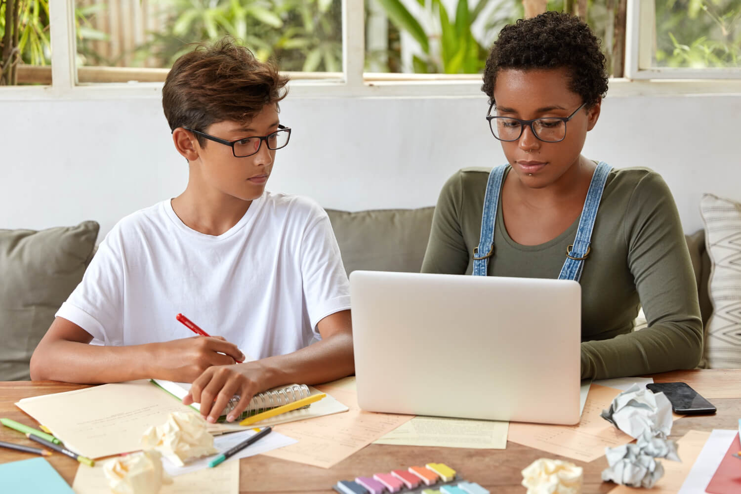 A woman helping her son with his job search.
